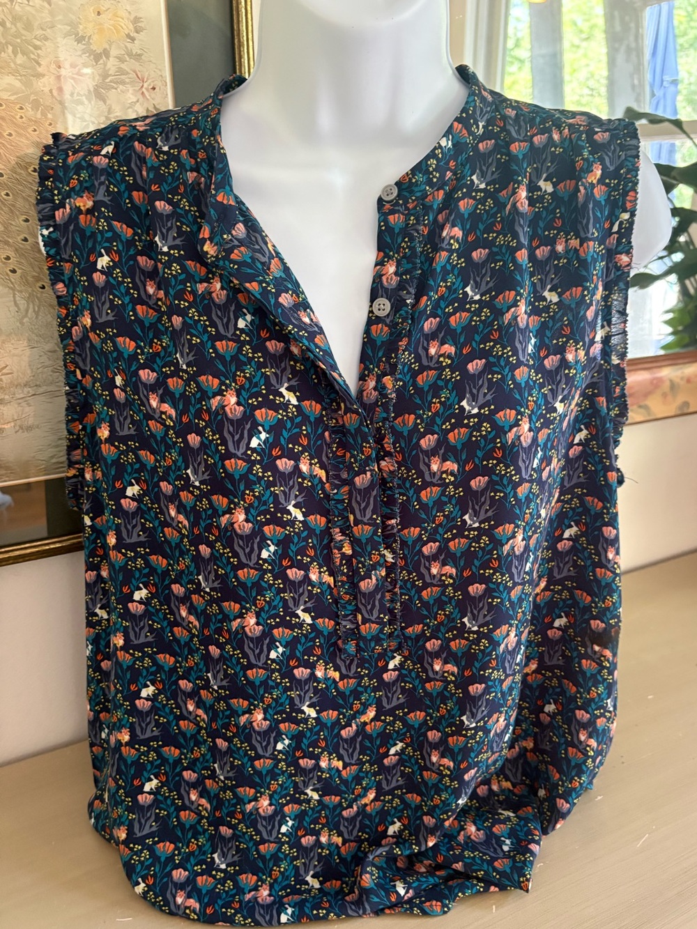Navy floral sleeveless blouse from LOFT featuring a ruffled button-down neckline